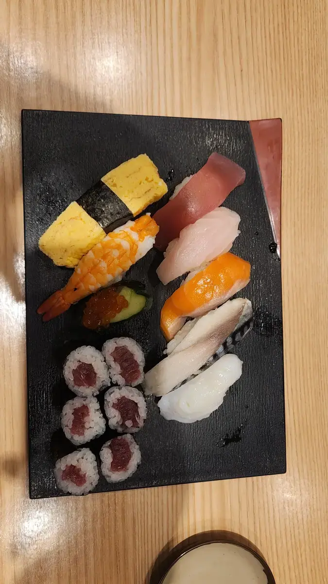 검은 접시에 담긴 초밥과 마끼 세트.
